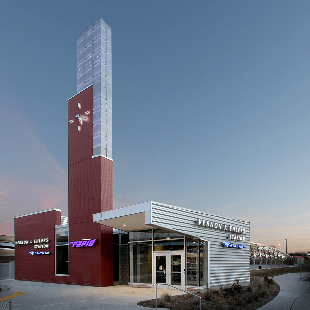 Vernon J. Ehlers Station with a distinctive clock tower and modern architecture at dusk.